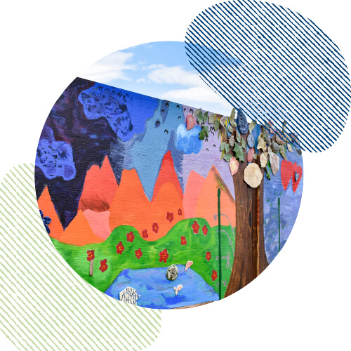 Mural of trees, water, mountains, and rain painted on plywood. This mural has a purple background and a yellow sun in the corner and was painted by Dismas House clients.