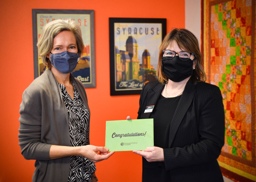 Check presentation – Washington Federal bank presents a card that reads “congratulations” to Chief Development and Communications Officer, Rachel Rodriguez.