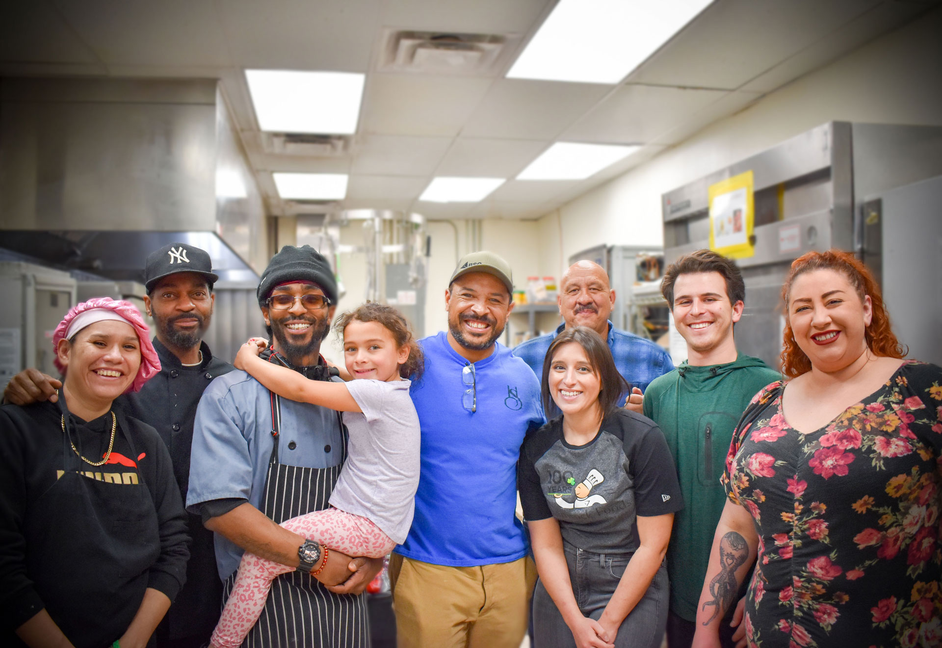 Volunteers from Hollow Spirits smile in a busy kitchen