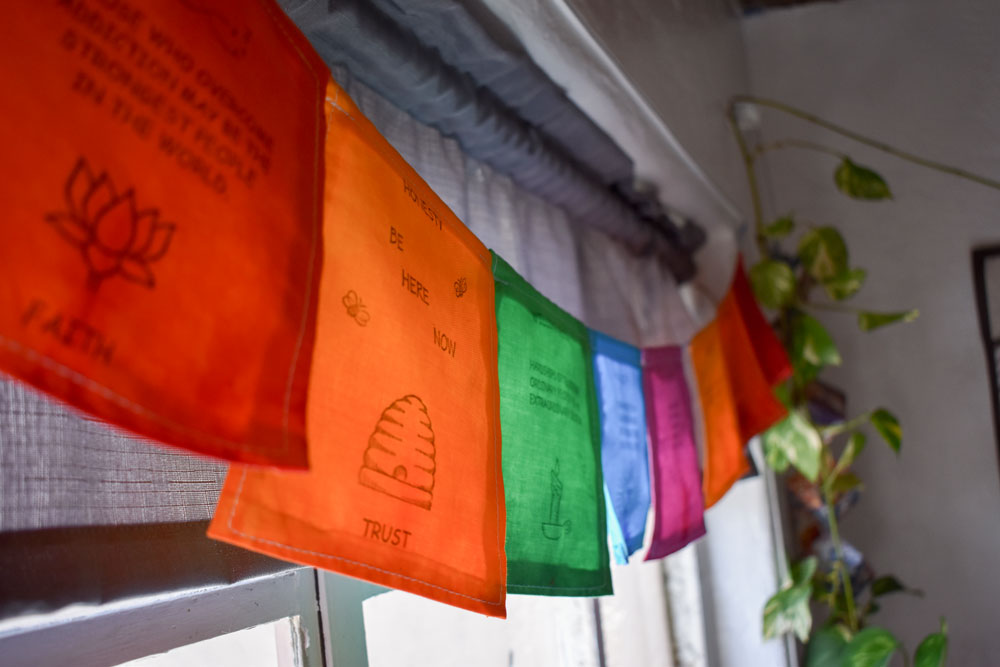 Papel Picado – Colorful papers hanging in the office at Dismas House. Papers are emblazoned with messages of peace and love.